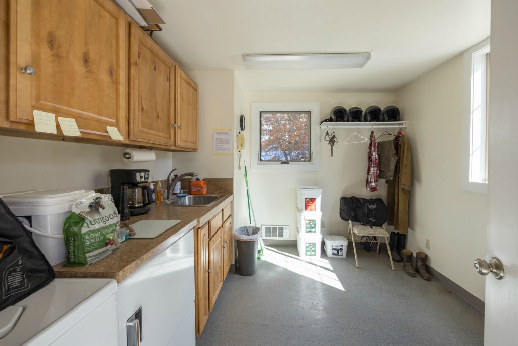 Wash room with sink and clothes washer and dryer, a full bath is next door.